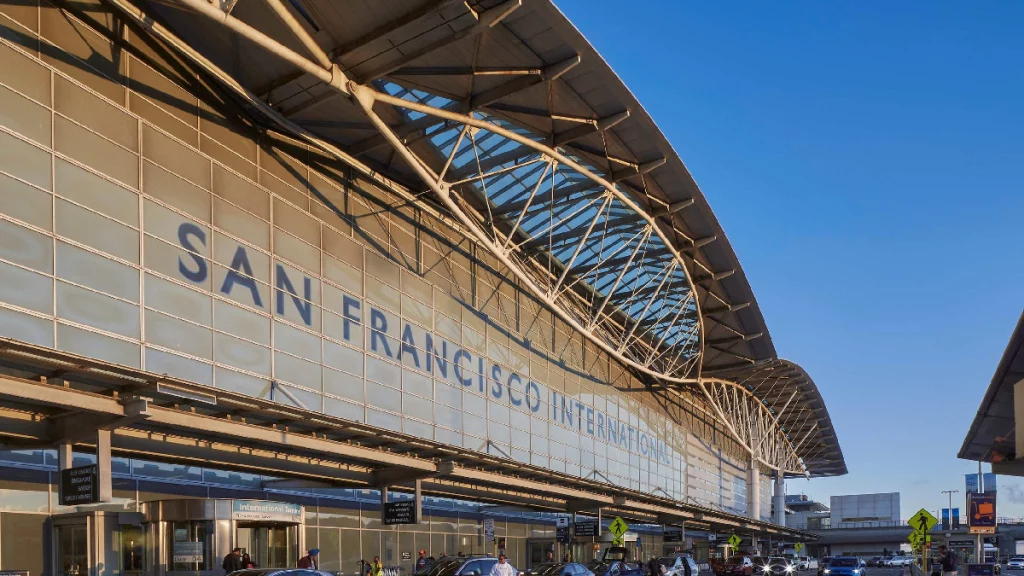 Chauffeur opening door of black luxury sedan for airport pickup at San Francisco International Airport